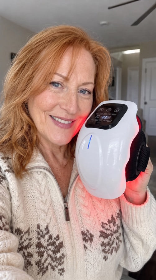 A woman holding the massager up beside her face, the red light lit